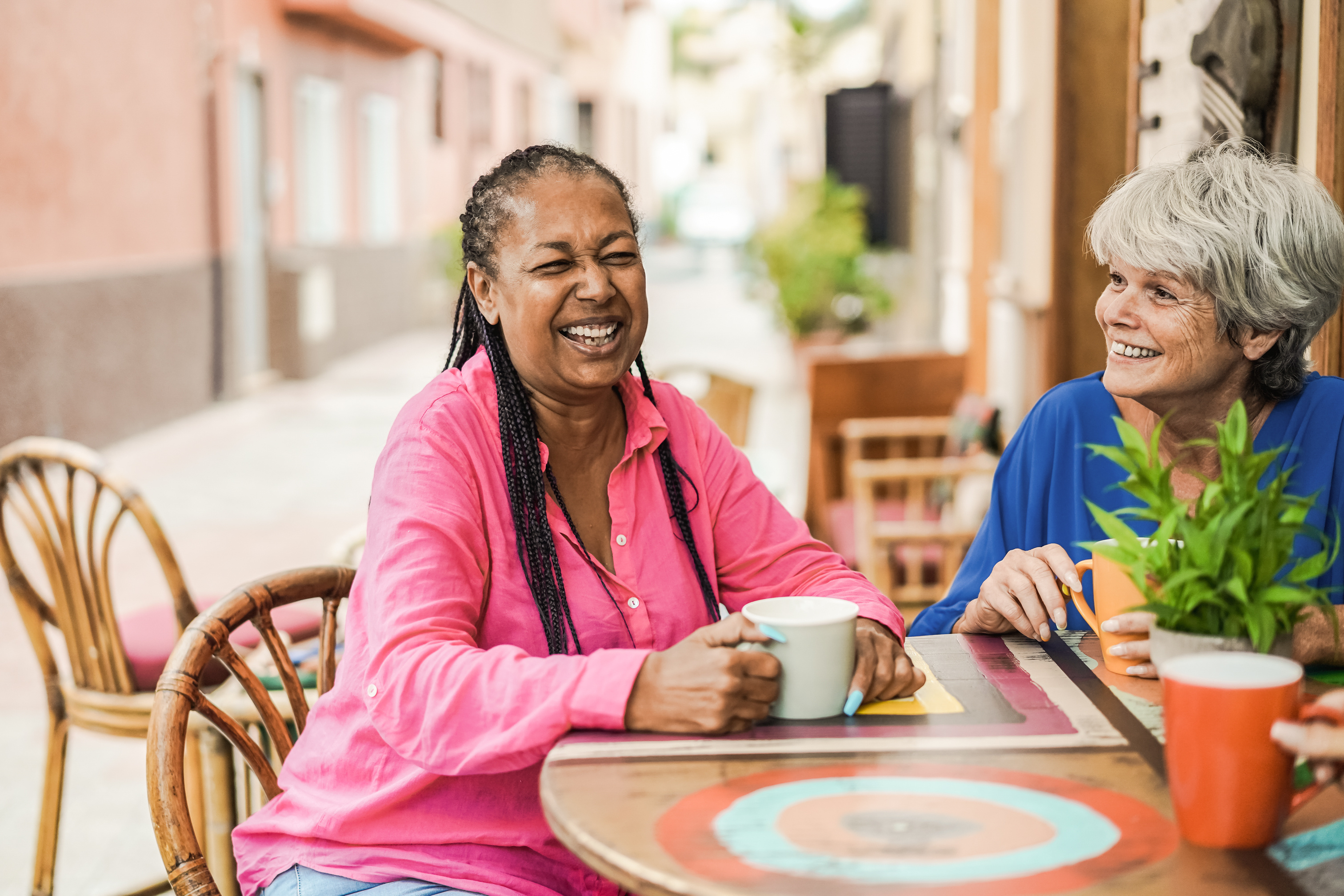 Two women connecting over coffee at an outdoor café.