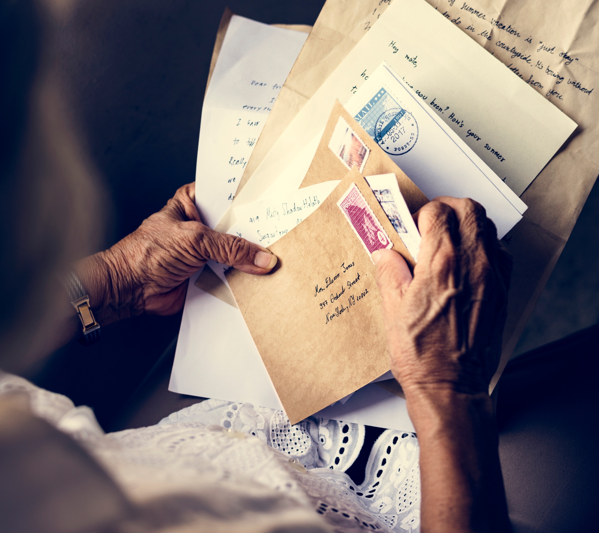 A woman looking through a collection of handwritten letters.